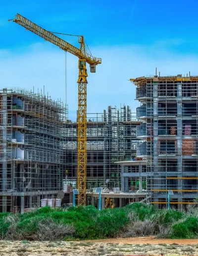 Tower crane over a multi-storey concrete frame under construction.
