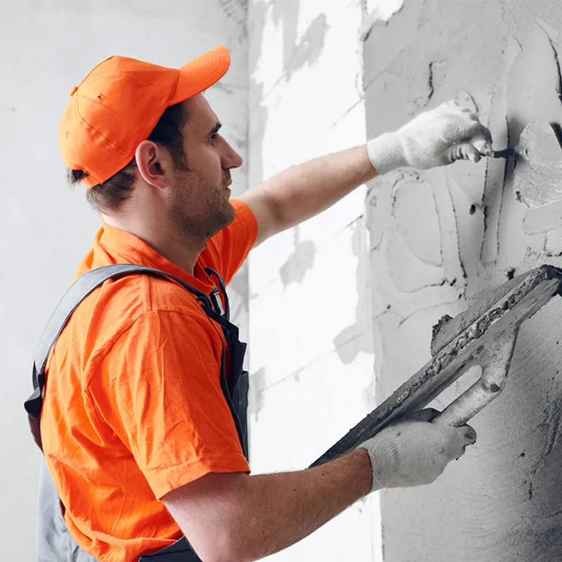 Plasterer skimming an interior wall smooth ahead of paint during a unit make-ready.